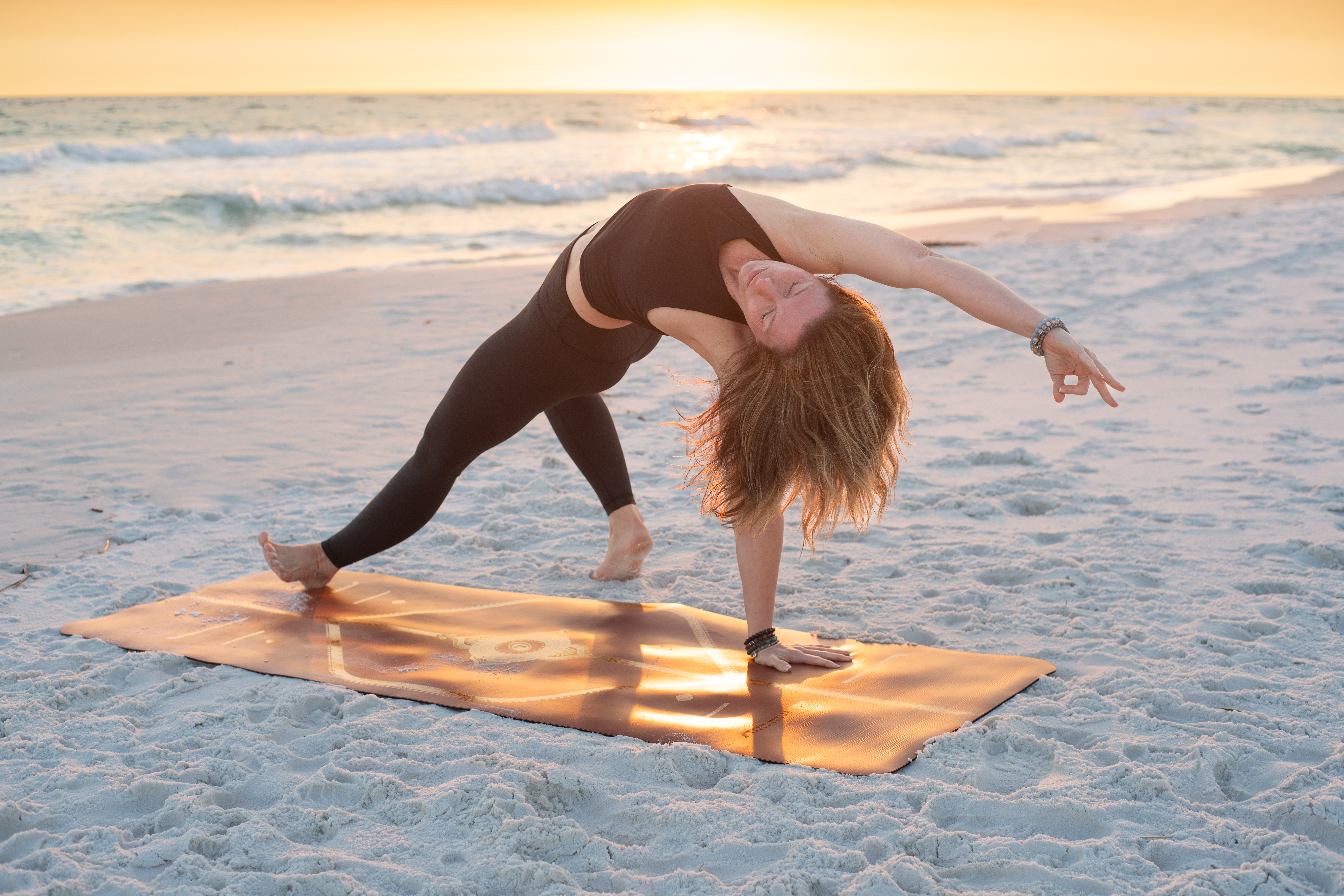 Stephanie in flipped dog yoga pose on the beach