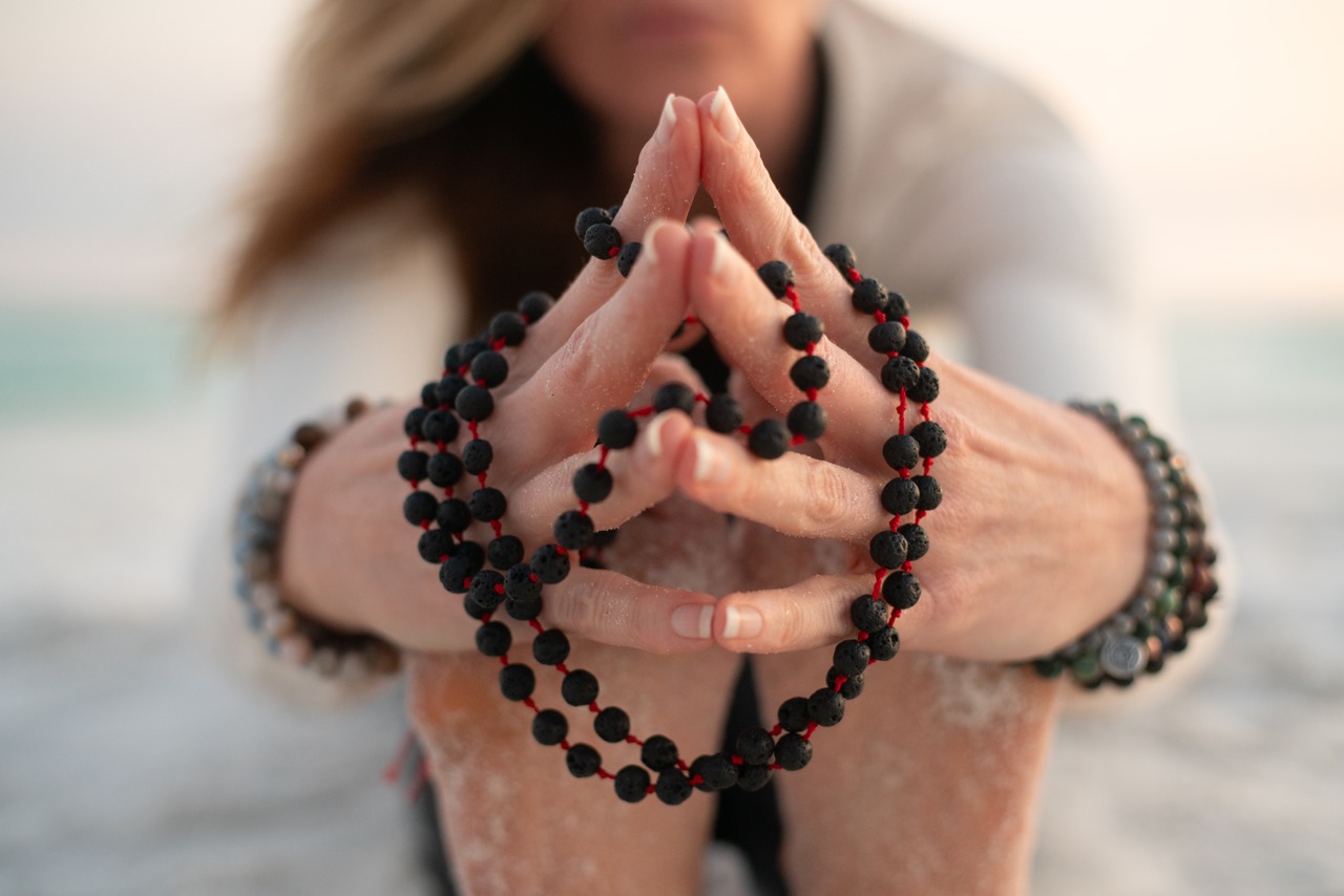 Stephanie's hands holding mala beads